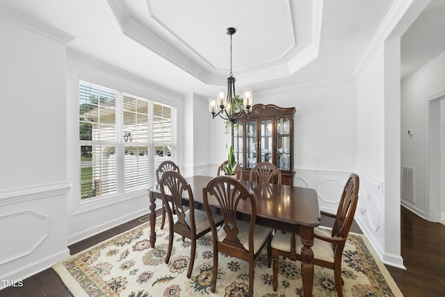 55 Kristopher Woods Dr, Youngsville, NC 27596 - dining space featuring a chandelier, dark wood finished floors, ornamental molding, a raised ceiling, and wainscoting