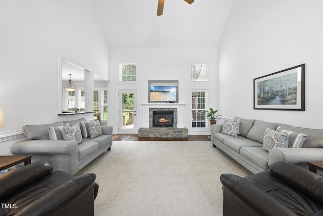 55 Kristopher Woods Dr, Youngsville, NC 27596 - living room with high vaulted ceiling, a ceiling fan, a stone fireplace, and wood finished floors