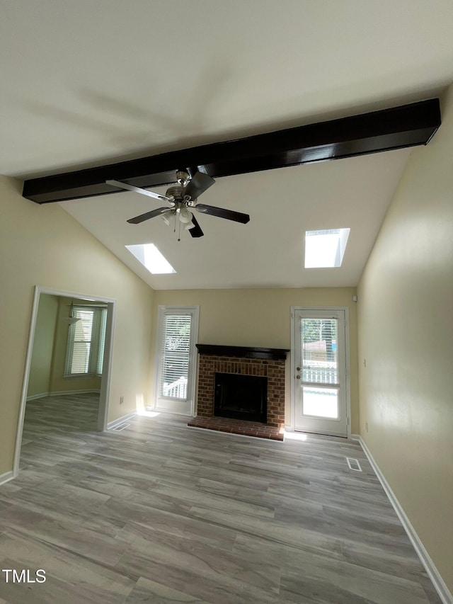 5 Sue Ann Ct, Durham, NC 27704 - unfurnished living room with a skylight, a fireplace, ceiling fan, and wood finished floors
