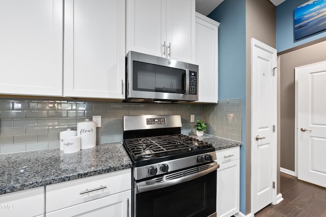 605 Smallwood Dr, Durham, NC 27703 - kitchen with stainless steel appliances, dark stone counters, decorative backsplash, dark wood-style flooring, and white cabinetry