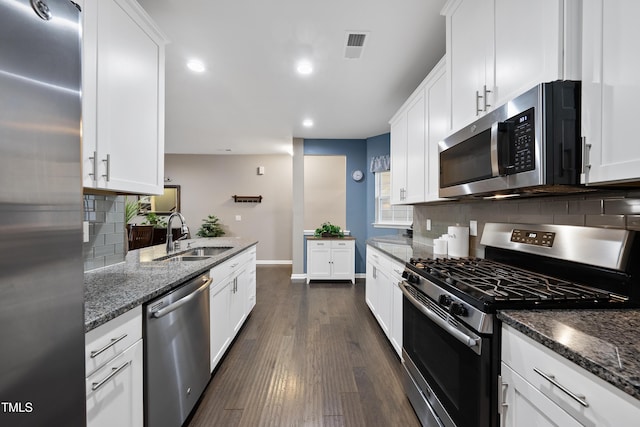 605 Smallwood Dr, Durham, NC 27703 - kitchen featuring appliances with stainless steel finishes, decorative backsplash, white cabinets, and recessed lighting