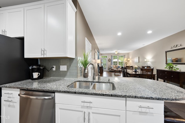 605 Smallwood Dr, Durham, NC 27703 - kitchen with stainless steel dishwasher, white cabinets, light stone counters, recessed lighting, and a peninsula