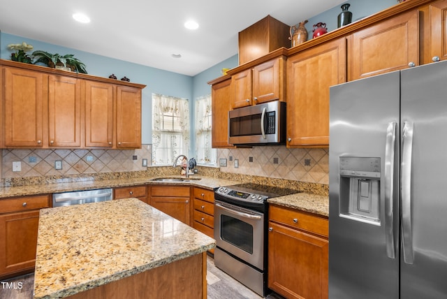 575 Tomkins Loop, Cary, NC 27519 - kitchen featuring appliances with stainless steel finishes, light stone countertops, brown cabinetry, tasteful backsplash, and recessed lighting