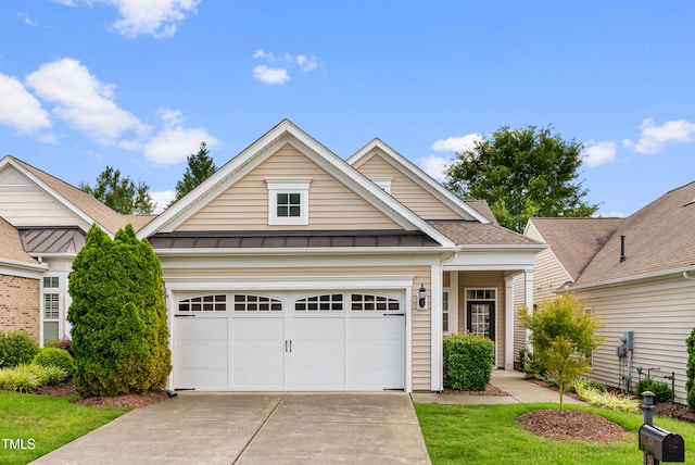 575 Tomkins Loop, Cary, NC 27519 - view of front facade with driveway, a standing seam roof, a garage, and a metal roof