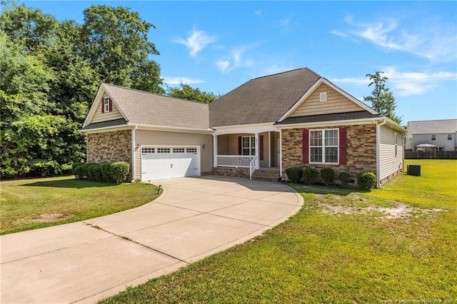 4817 Kiara Dr, Hope Mills, NC 28348 - view of front of house with covered porch, an attached garage, driveway, a front yard, and stone siding