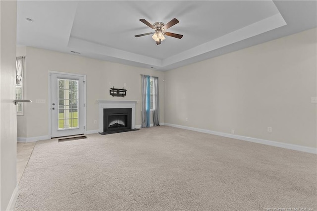 4817 Kiara Dr, Hope Mills, NC 28348 - unfurnished living room with a tray ceiling, light carpet, ceiling fan, and a fireplace with flush hearth