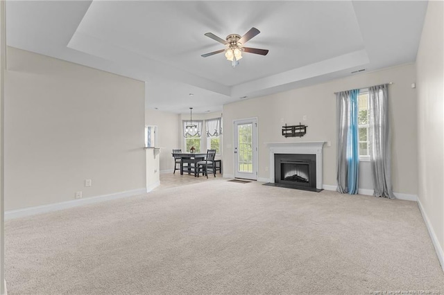 4817 Kiara Dr, Hope Mills, NC 28348 - carpeted living room featuring a tray ceiling, ceiling fan, and a fireplace with flush hearth