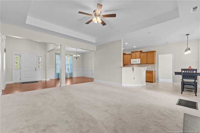 4817 Kiara Dr, Hope Mills, NC 28348 - unfurnished living room with light colored carpet, a chandelier, a tray ceiling, and recessed lighting