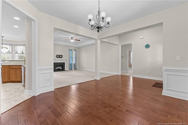 4817 Kiara Dr, Hope Mills, NC 28348 - unfurnished dining area with a chandelier, hardwood / wood-style floors, a ceiling fan, a fireplace, and healthy amount of natural light
