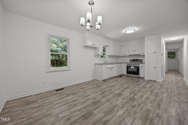 37 Weeping Willow Ln, Lillington, NC 27546 - kitchen featuring stainless steel range with electric cooktop, under cabinet range hood, white cabinetry, light wood finished floors, and pendant lighting