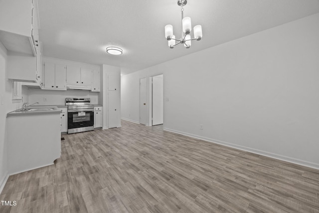 37 Weeping Willow Ln, Lillington, NC 27546 - kitchen with electric range, under cabinet range hood, a chandelier, light wood-style flooring, and white cabinets