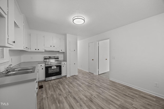 37 Weeping Willow Ln, Lillington, NC 27546 - kitchen with electric stove, light wood-style floors, white cabinetry, a textured ceiling, and under cabinet range hood