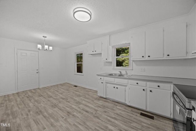 37 Weeping Willow Ln, Lillington, NC 27546 - kitchen featuring a textured ceiling, a chandelier, stainless steel range with electric cooktop, white cabinetry, and light wood-style flooring
