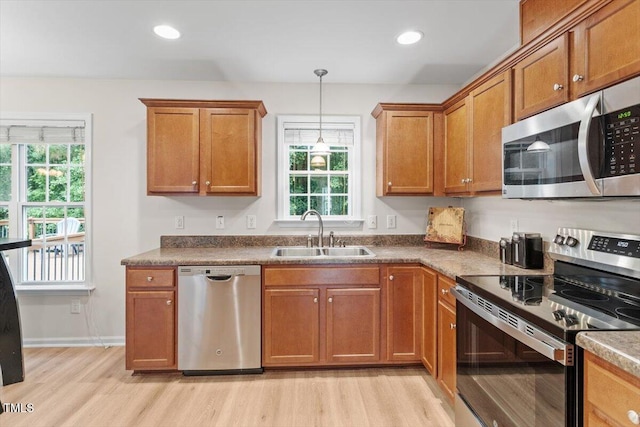 161 Jacob St, Holly Springs, NC 27540 - kitchen featuring stainless steel appliances, light wood-style flooring, brown cabinets, healthy amount of natural light, and recessed lighting