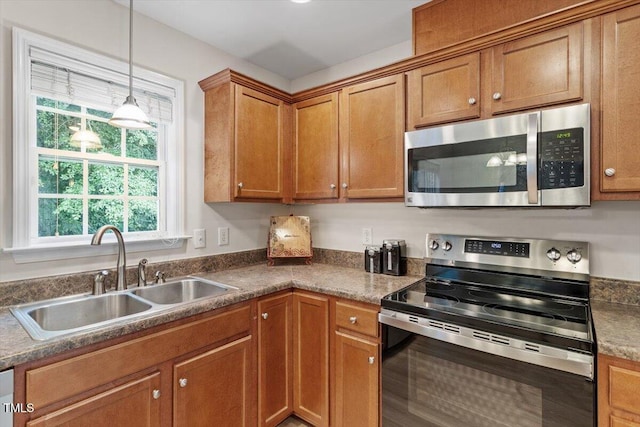 161 Jacob St, Holly Springs, NC 27540 - kitchen featuring stainless steel appliances, brown cabinets, hanging light fixtures, and dark countertops