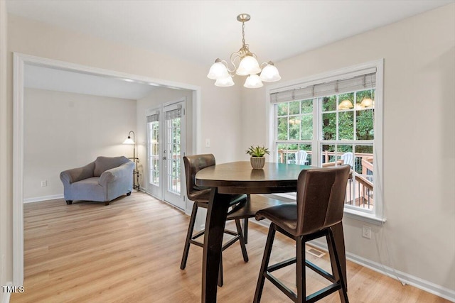161 Jacob St, Holly Springs, NC 27540 - dining space with a chandelier, healthy amount of natural light, light wood-style flooring, and french doors