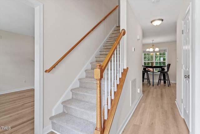 161 Jacob St, Holly Springs, NC 27540 - stairs featuring wood finished floors and a chandelier