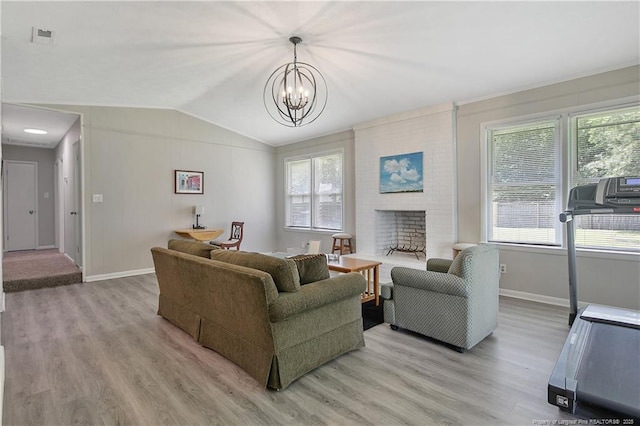 6501 Senator Dr, Fayetteville, NC 28304 - living room featuring light wood finished floors, vaulted ceiling, a chandelier, and a fireplace