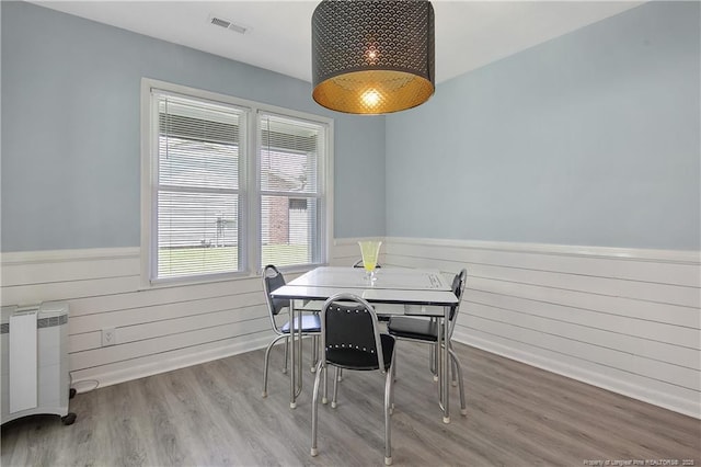6501 Senator Dr, Fayetteville, NC 28304 - dining space featuring a wainscoted wall, wood finished floors, wooden walls, and radiator