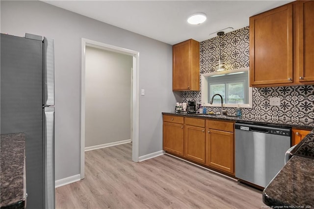 6501 Senator Dr, Fayetteville, NC 28304 - kitchen with appliances with stainless steel finishes, light wood-style floors, tasteful backsplash, and brown cabinets