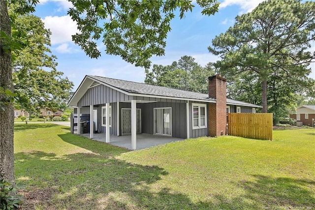 6501 Senator Dr, Fayetteville, NC 28304 - rear view of property with board and batten siding, a patio, roof with shingles, and a chimney