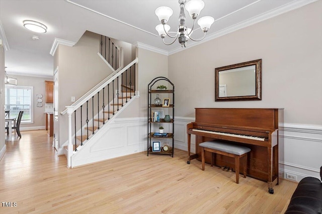1505 Mclaurin Ln, Fuquay Varina, NC 27526 - staircase featuring a chandelier, crown molding, wood finished floors, a wainscoted wall, and a decorative wall