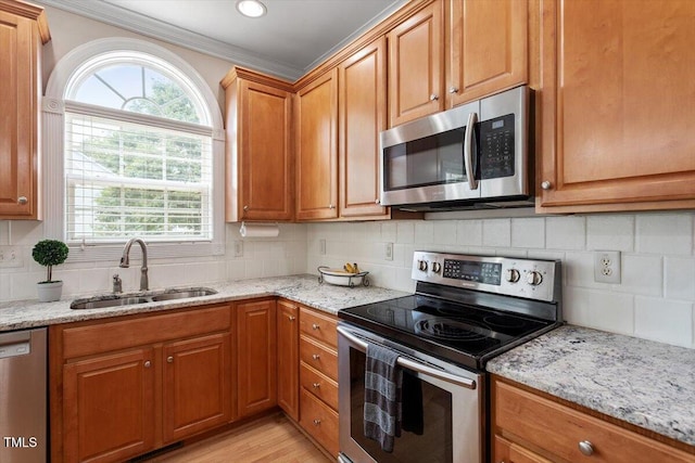 1505 Mclaurin Ln, Fuquay Varina, NC 27526 - kitchen featuring stainless steel appliances, crown molding, light stone countertops, backsplash, and brown cabinets