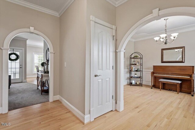 1505 Mclaurin Ln, Fuquay Varina, NC 27526 - foyer featuring arched walkways, light wood-style flooring, ornamental molding, and a chandelier