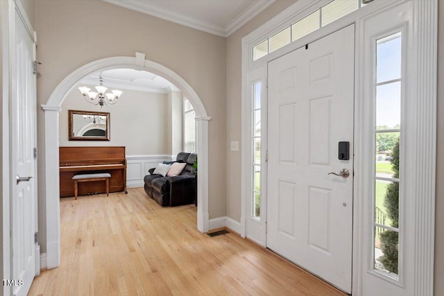 1505 Mclaurin Ln, Fuquay Varina, NC 27526 - entryway with crown molding, light wood finished floors, a chandelier, and arched walkways