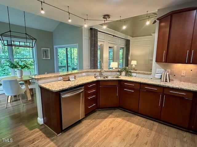 1113 Bexley Hills Bnd, Apex, NC 27502 - kitchen with dishwasher, vaulted ceiling, light wood finished floors, rail lighting, and a peninsula