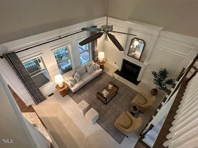 1113 Bexley Hills Bnd, Apex, NC 27502 - living area featuring a decorative wall, ceiling fan, and a fireplace