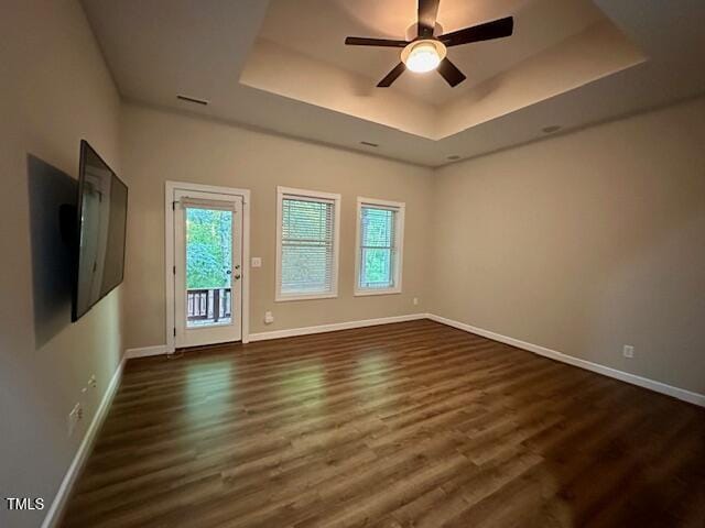 1113 Bexley Hills Bnd, Apex, NC 27502 - unfurnished room featuring a tray ceiling, dark wood finished floors, and a ceiling fan