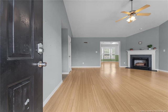 159 Falling Leaf Dr, Raeford, NC 28376 - unfurnished living room with light wood-type flooring, a ceiling fan, a fireplace with flush hearth, and vaulted ceiling