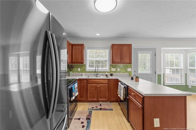 159 Falling Leaf Dr, Raeford, NC 28376 - kitchen with appliances with stainless steel finishes, a peninsula, light wood-style flooring, light countertops, and healthy amount of natural light