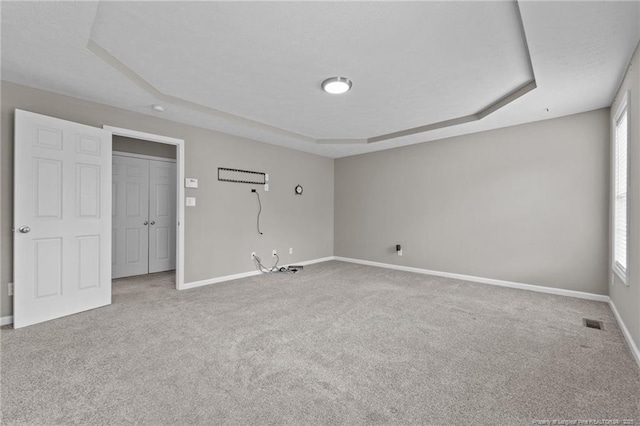 159 Falling Leaf Dr, Raeford, NC 28376 - unfurnished bedroom featuring a tray ceiling, carpet, and multiple windows
