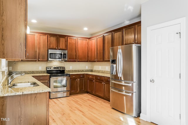 165 Sutherland Dr, Franklinton, NC 27525 - kitchen featuring appliances with stainless steel finishes, light stone counters, light wood finished floors, and recessed lighting