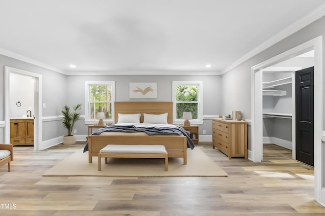 1112 Lakeside Dr NW, Wilson, NC 27896 - bedroom featuring multiple windows, a spacious closet, ornamental molding, recessed lighting, and light wood-type flooring
