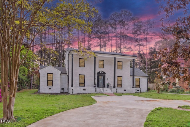 1112 Lakeside Dr NW, Wilson, NC 27896 - view of front facade with driveway, a yard, brick siding, and crawl space