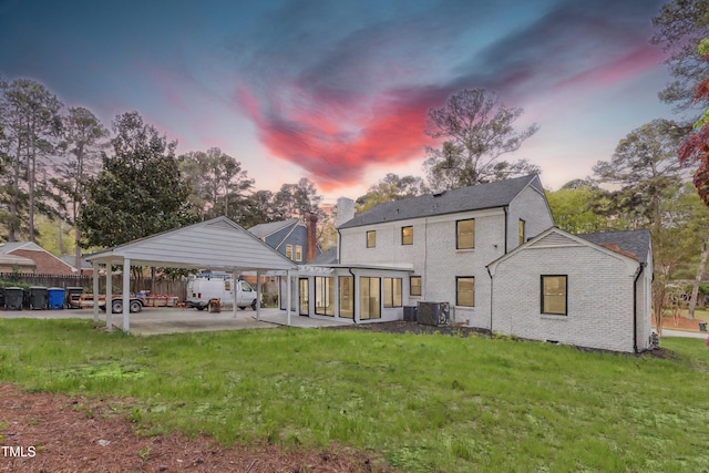 1112 Lakeside Dr NW, Wilson, NC 27896 - back of house featuring a detached carport, a yard, brick siding, and a sunroom