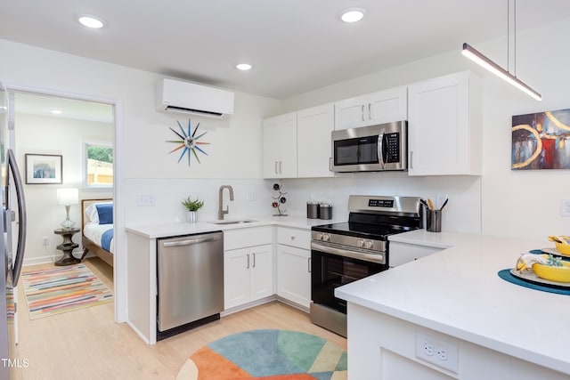 1309 Hudson Ave Unit D6, Durham, NC 27705 - kitchen with appliances with stainless steel finishes, a wall mounted AC, light wood finished floors, light countertops, and decorative backsplash