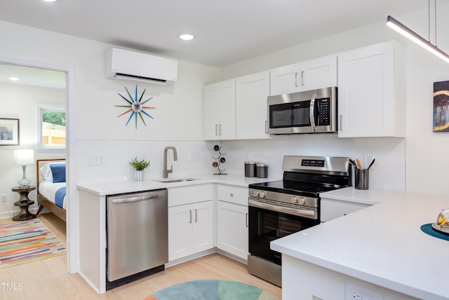 1309 Hudson Ave Unit D6, Durham, NC 27705 - kitchen featuring appliances with stainless steel finishes, a wall mounted air conditioner, light wood-type flooring, decorative backsplash, and recessed lighting