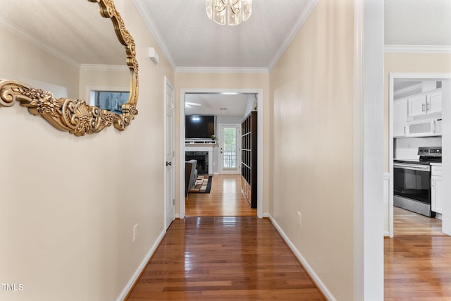 3109 Gold Dust Ln, Willow Springs, NC 27592 - hallway with wood finished floors, a chandelier, crown molding, and a textured ceiling
