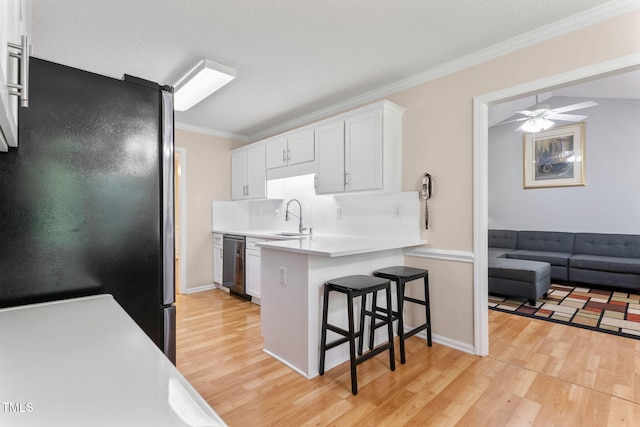 3109 Gold Dust Ln, Willow Springs, NC 27592 - kitchen with freestanding refrigerator, dishwashing machine, a kitchen bar, light wood-style flooring, and light countertops
