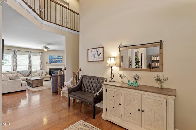 1413 Lily Creek Dr, Cary, NC 27518 - living room with ceiling fan, light wood-style flooring, a glass covered fireplace, and a towering ceiling