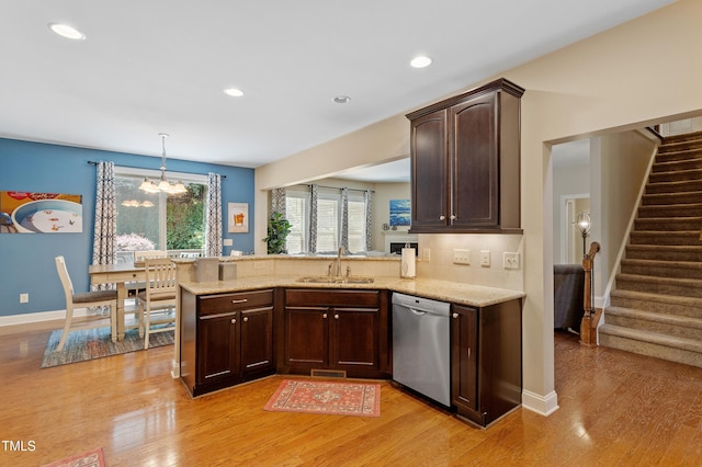 1413 Lily Creek Dr, Cary, NC 27518 - kitchen featuring stainless steel dishwasher, dark brown cabinets, a chandelier, light wood finished floors, and a peninsula