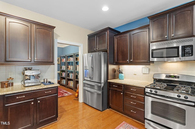 1413 Lily Creek Dr, Cary, NC 27518 - kitchen featuring appliances with stainless steel finishes, backsplash, light wood-style floors, dark brown cabinets, and recessed lighting