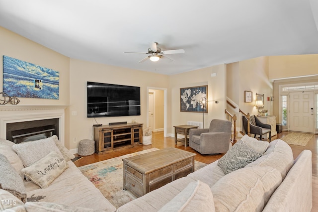 1413 Lily Creek Dr, Cary, NC 27518 - living area with stairs, a ceiling fan, wood finished floors, and a glass covered fireplace