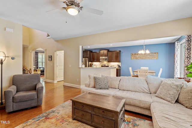 1413 Lily Creek Dr, Cary, NC 27518 - living area featuring a chandelier, light wood-type flooring, a ceiling fan, arched walkways, and decorative columns