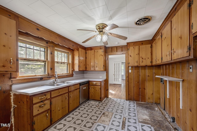 2715 E Geer St, Durham, NC 27704 - kitchen with stainless steel dishwasher, brown cabinets, light countertops, a ceiling fan, and wood walls