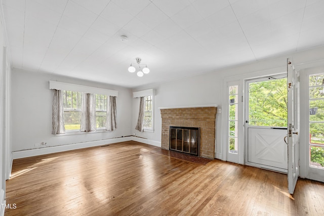 2715 E Geer St, Durham, NC 27704 - unfurnished living room featuring healthy amount of natural light, hardwood / wood-style flooring, and a brick fireplace